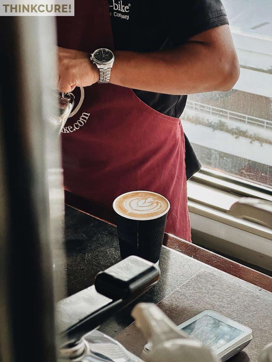 a man standing in front of a window next to a cup of coffee